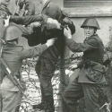 Na fotografii z 18. srpna 1962 odnášejí němečtí strážníci umírajícího osmnáctiletého Petera Fechtera, který se pokusil překonat zeď a utéct do Západního Berlína.
