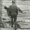 Na této fotografii německý pohraničník odnáší již mrtvé tělo zastřeleného osmnáctiletého Petera Fechtera.
